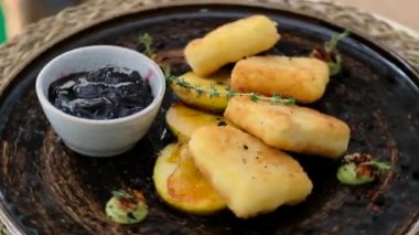 Kızarmış camembert peyniri, kızılcık sosuyla servis ediliyor.