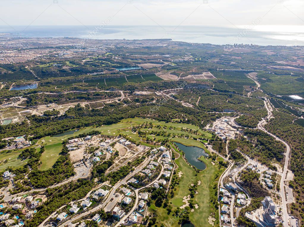 Aerial photo drone point of view golf club with modern villas and apartments on Costa Blanca, Alicante. Sport and recreation tourism concept. Spain