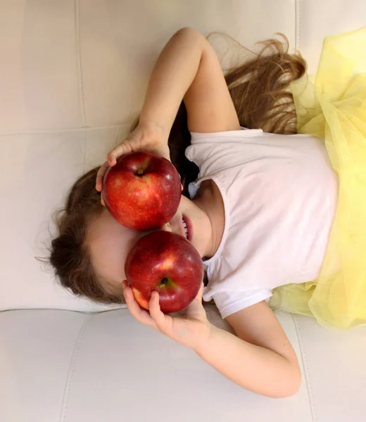 Attraktives kleines Mädchen hält einen roten Apfel in der Hand — Stockfoto