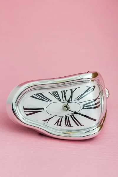 Clock with distorted soft melting design on pink background