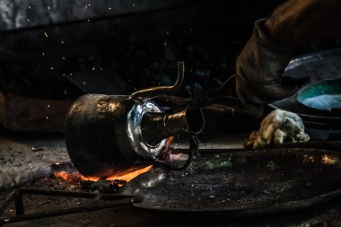 Kalay bakır nesnesiyle ateşte kapsayan geleneksel Türk tenekeci