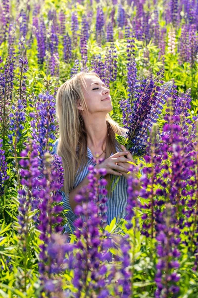 Ung kvinna tycker om blommor — Stockfoto