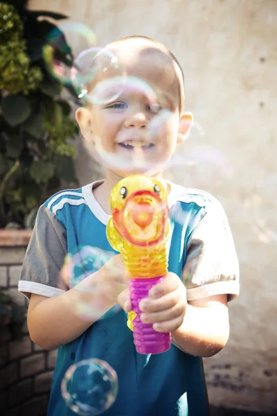 Boy doing soap bubbles in the garden — Stock Photo, Image