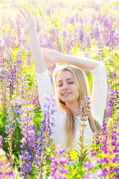 Young happy woman on the field in flowers — Stock Photo, Image