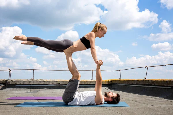 Man och kvinna är engagerade i acro yoga — Stockfoto