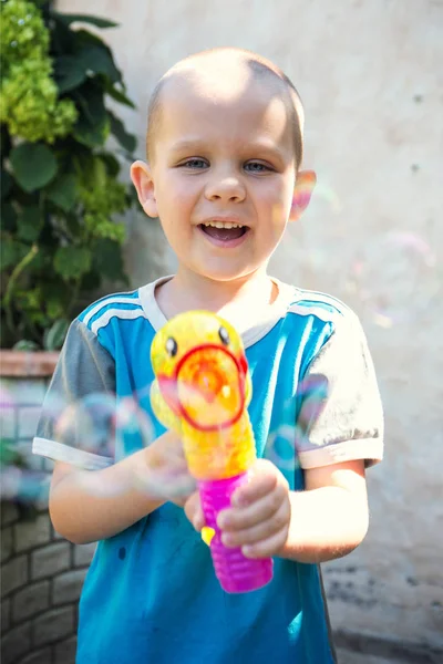 Little boy doing soap bubbles in the garden — Stock Photo, Image