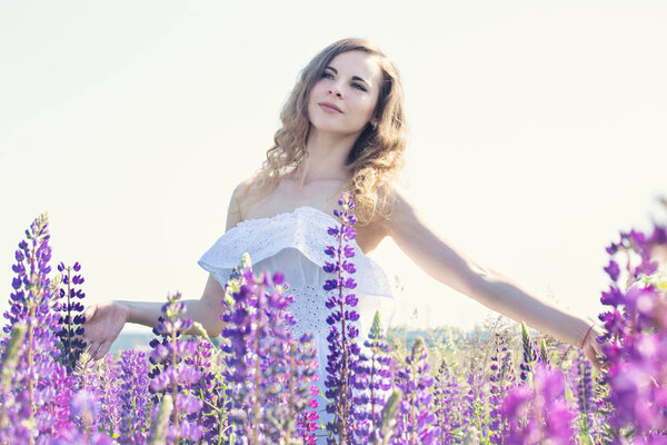 Beautiful tender woman in a field of flowers