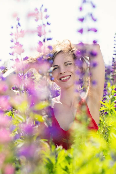Una donna guarda fuori da dietro i fiori — Foto Stock