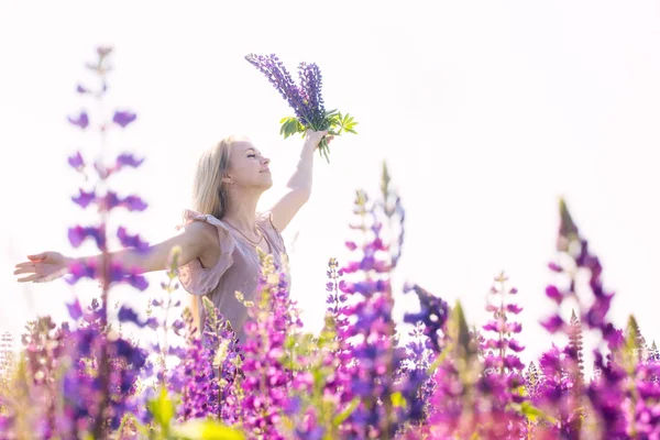 Happy woman with bouquet of lupines — Stock Photo, Image