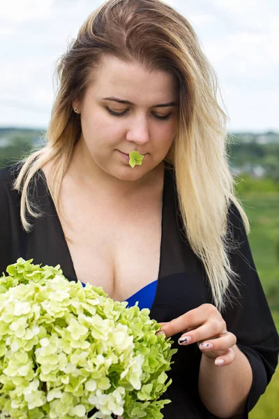 Mladá žena s kytice z hortenzií — Stock fotografie