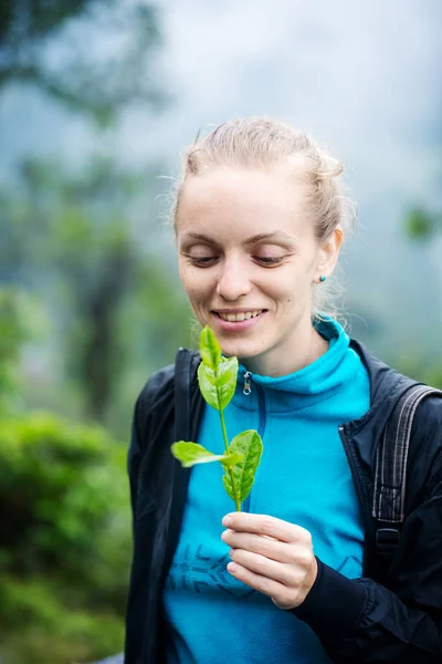 Menina feliz com um ramo de uma árvore de chá — Fotografia de Stock