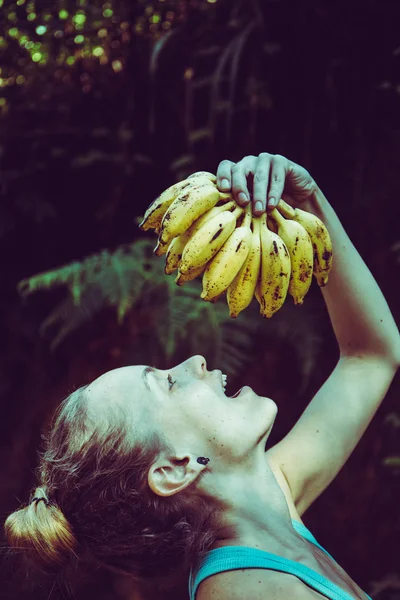La chica está comiendo plátanos. — Foto de Stock