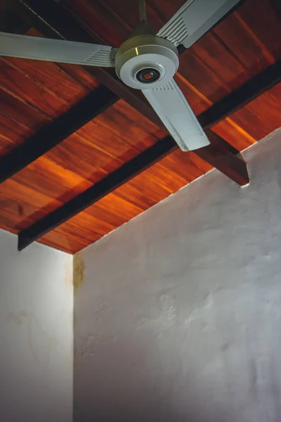Ceiling fan on a brown wooden ceiling