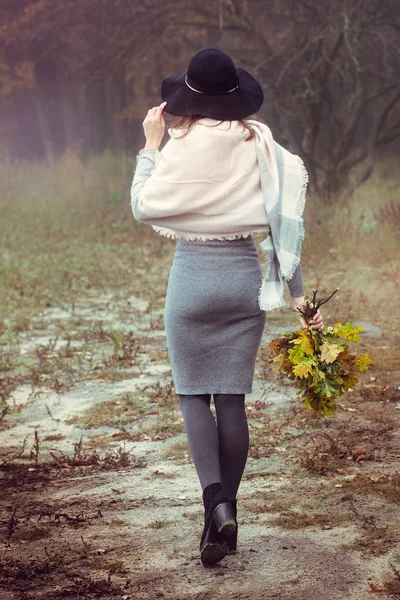 Woman with a bouquet of leaves with her back — Stock Photo, Image