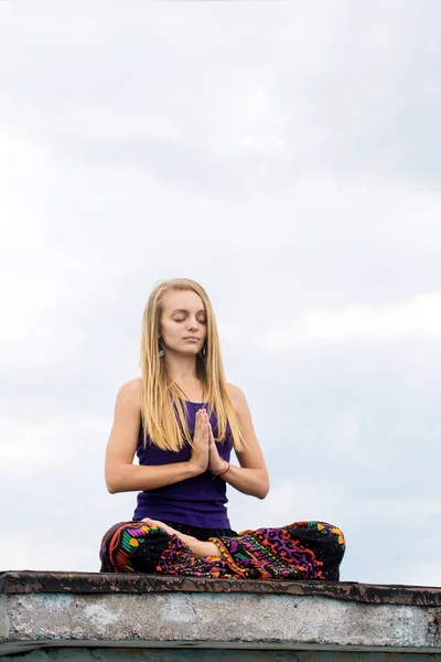 Mulher em uma pose de lótus no telhado — Fotografia de Stock