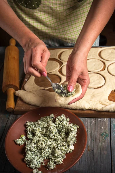 Женщина кладет начинку в тесто — стоковое фото