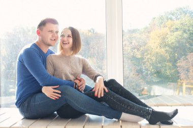 bir pencere üzerinde oturan çift