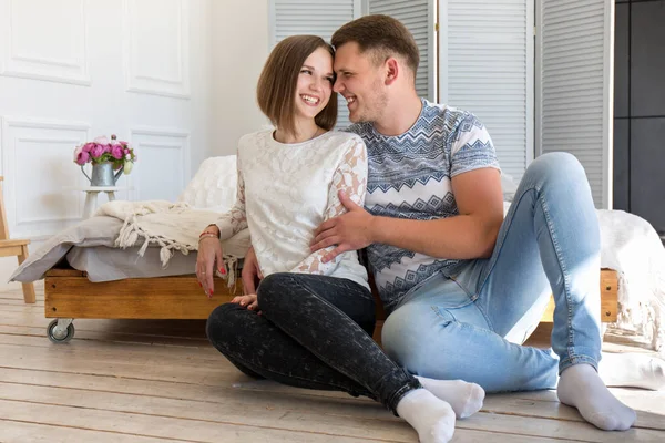 Glückliches Paar auf dem Boden sitzend — Stockfoto