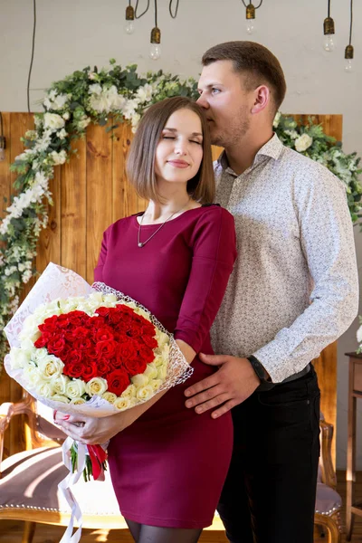 Casal apaixonado por um grande buquê de rosas — Fotografia de Stock