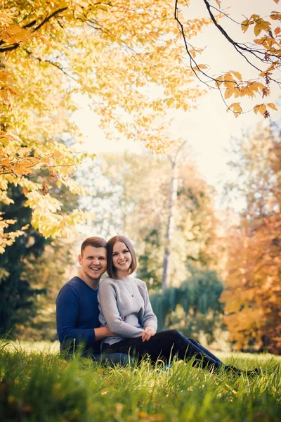 Çimenlerin üzerinde oturan genç güzel çift — Stok fotoğraf