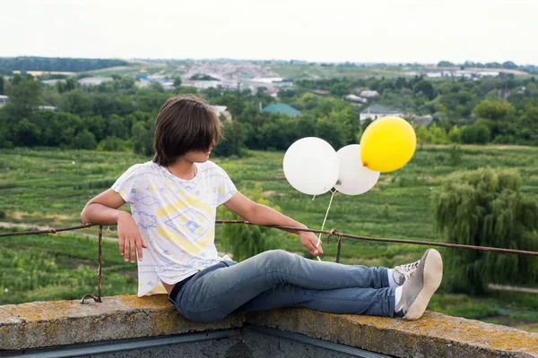 Adam balonlarla oturur — Stok fotoğraf