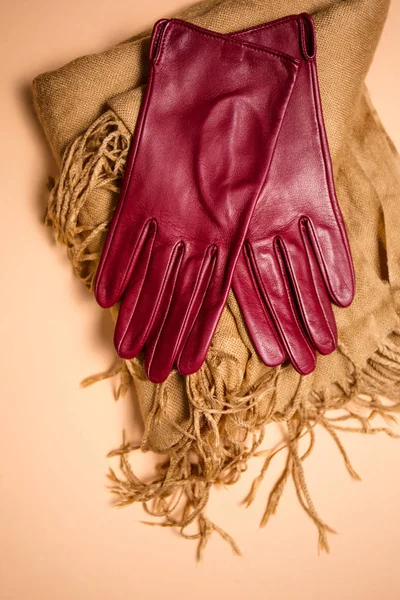 Stylish red leather gloves on a scarf