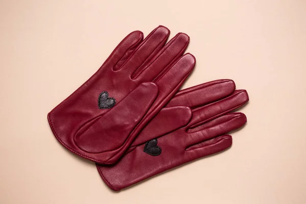 Бургундские кожаные перчатки с сердцем на ладони — стоковое фото