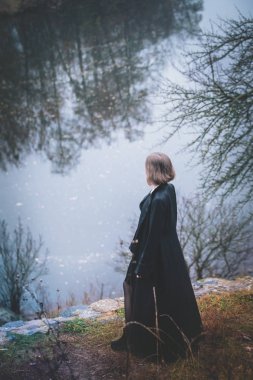 Bir kız nehir, yukarıda bir uçuruma görüntülemek yukarıdan