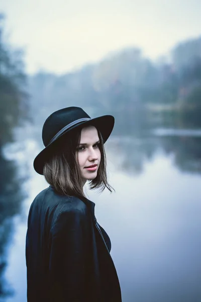 Pensive girl in a hat by the river — Stock Photo, Image