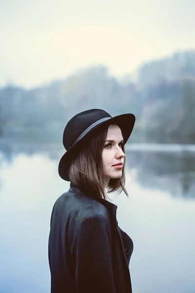 Bella ragazza con un cappello vicino al fiume — Foto Stock