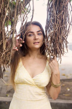 Banyan tree yakınındaki genç uzun saçlı kadın