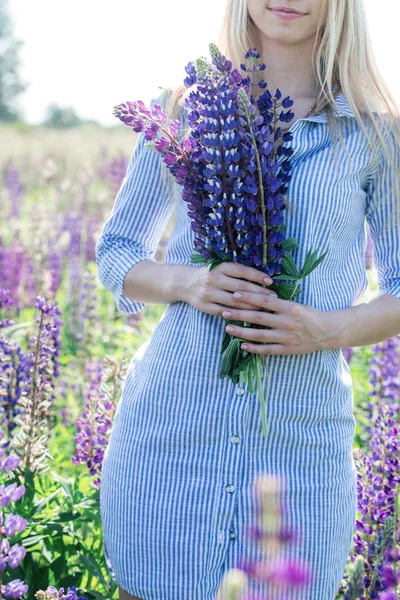 美丽的金发女郎在田野里盛开的 Lupines — 图库照片