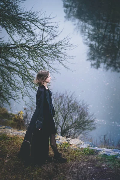 Жінка Довгій Чорній Шубці Над Скелею Над Річкою — стокове фото