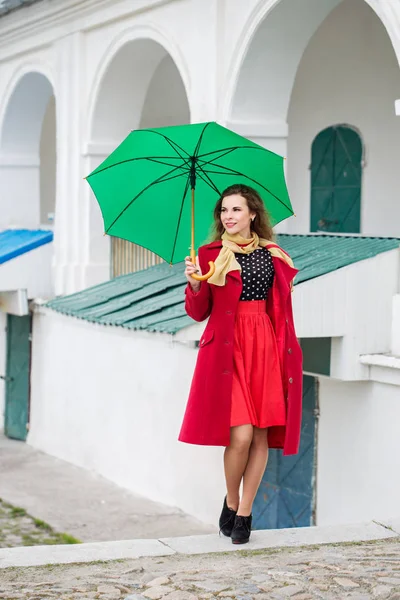 Güzel Kadın Kırmızı Paltolu Bir Yeşil Şemsiye Tutan — Stok fotoğraf
