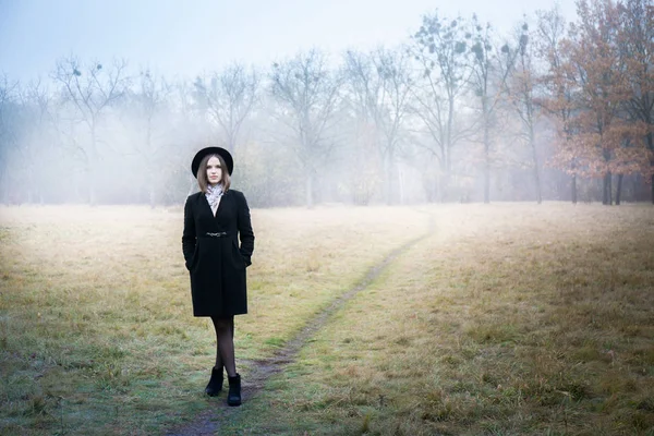 黒いコートと霧の帽子の女性 ストック画像