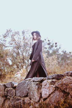 Nehrin üzerinde bir uçuruma uzun siyah bir ceket kadında