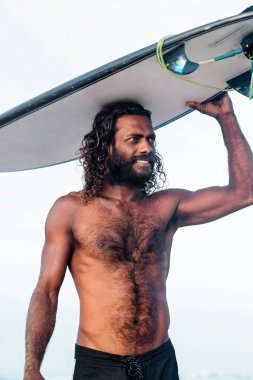 Bir genç esmer yakışıklı bir surfboard ile