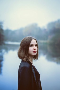 Nehrin üzerinde bir uçuruma uzun siyah bir ceket kadında