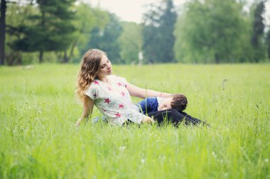 Anne, yavaşça bir çayır üzerinde dinlenme oğlu okşadı