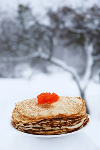 血色の良いパンケーキと冬の風景の背景に赤いキャビア プレート お祝いのための概念節 — ストック写真