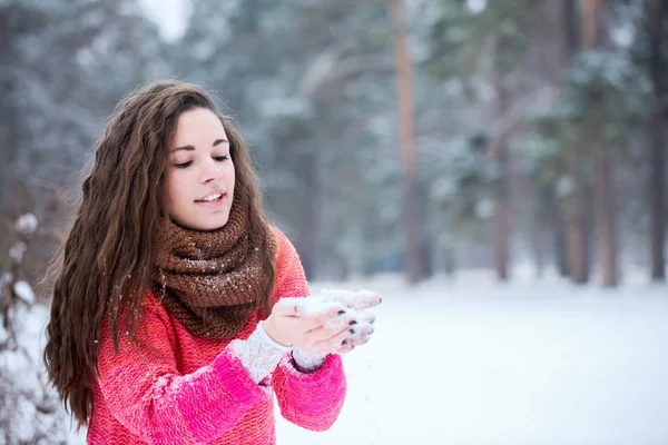 年轻美丽的女人在雪地上吹着手 — 图库照片