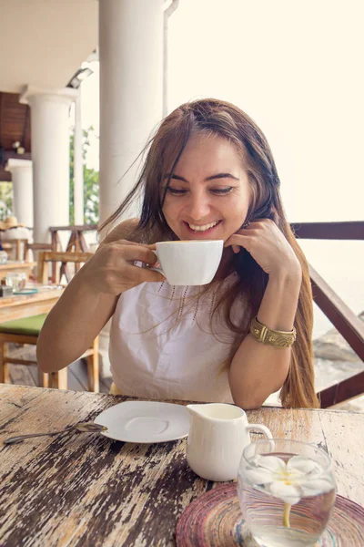 女性は カフェでカプチーノを飲んでいます — ストック写真