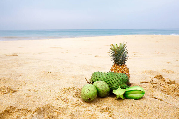 Exotic fruits on the sand near the ocean