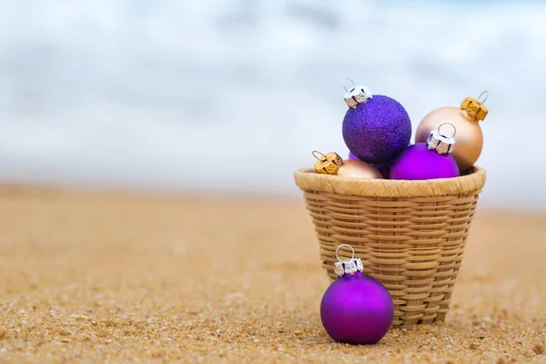 Christmas balls on a sandy beach by the ocean