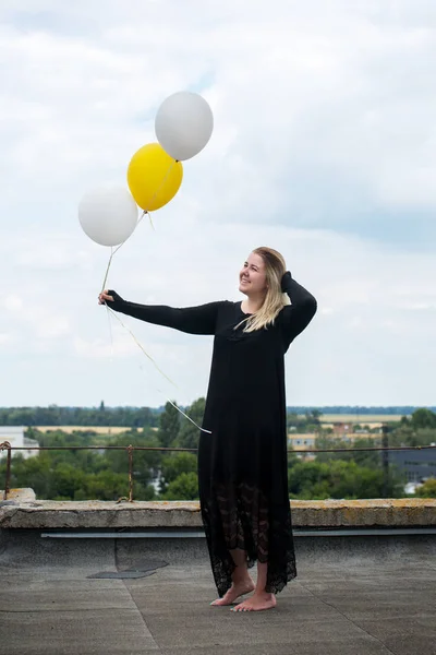 屋根の上の風船を持つ若い陽気な女性 — ストック写真