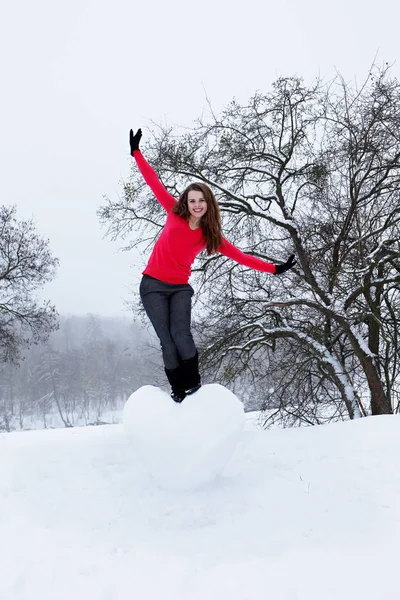 雪で作られた巨大な心と美しい女性 — ストック写真