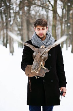 Yakışıklı delikanlı bir şahin kolunu tutan