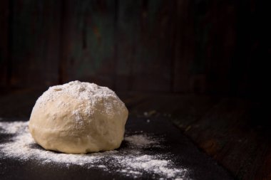 Bir kara tahta üzerinde un ile hamur serpilir