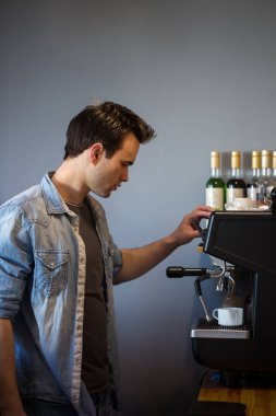 Bir adam bir kahve makinesi kullanarak kahve