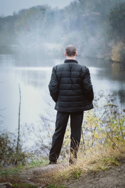 Nehir kıyısında bir sıcak siyah ceketli adamı emekli